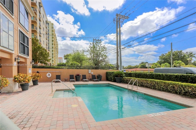 community pool featuring a patio and fence