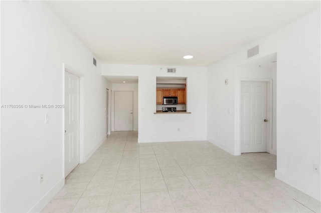 empty room featuring baseboards, recessed lighting, light tile patterned flooring, and visible vents