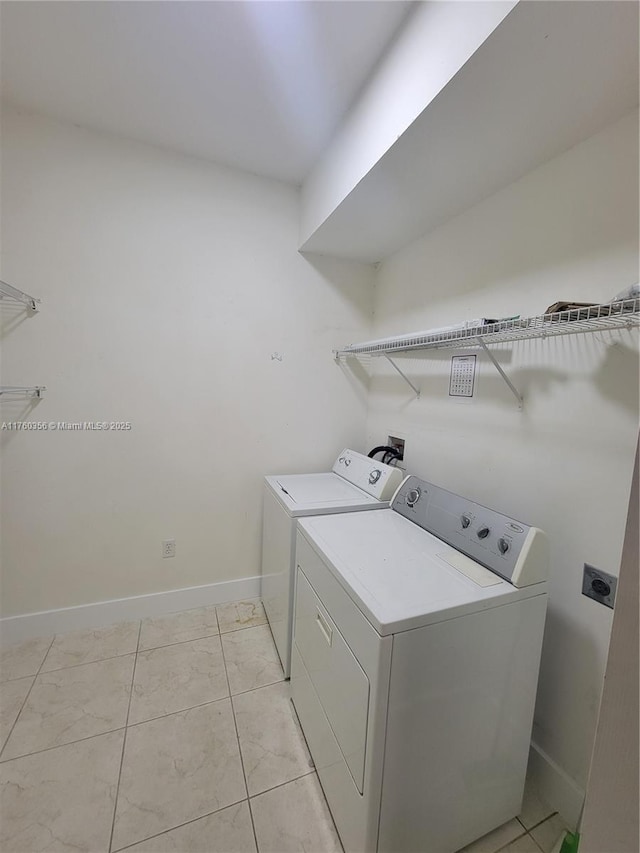 clothes washing area featuring laundry area, baseboards, and separate washer and dryer