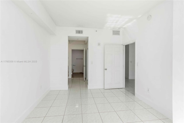 spare room featuring light tile patterned floors, baseboards, and visible vents