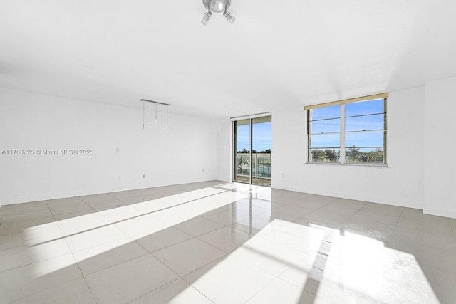 10000 W Bay Harbor Dr Unit 403, Bay Harbor Islands, FL 33154 - tiled empty room featuring a wall of windows and baseboards