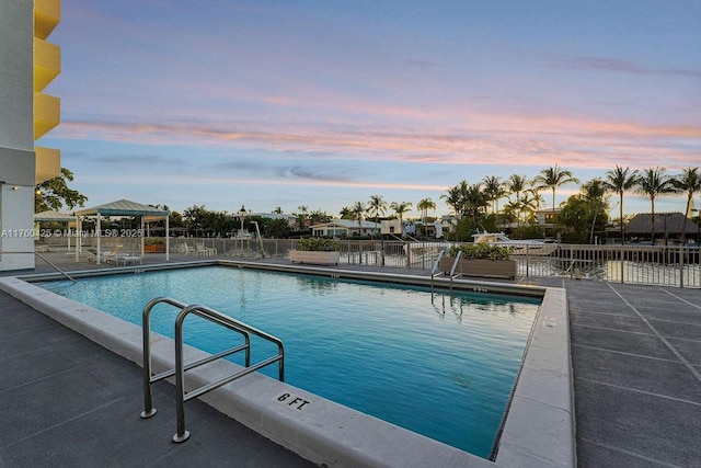 community pool with a patio and fence