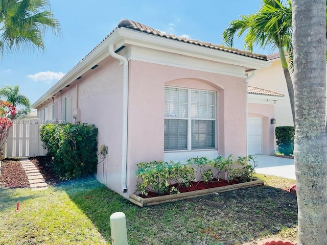 6938 NW 33rd St, Margate, FL 33063 - view of property exterior with a tiled roof, stucco siding, a garage, and concrete driveway
