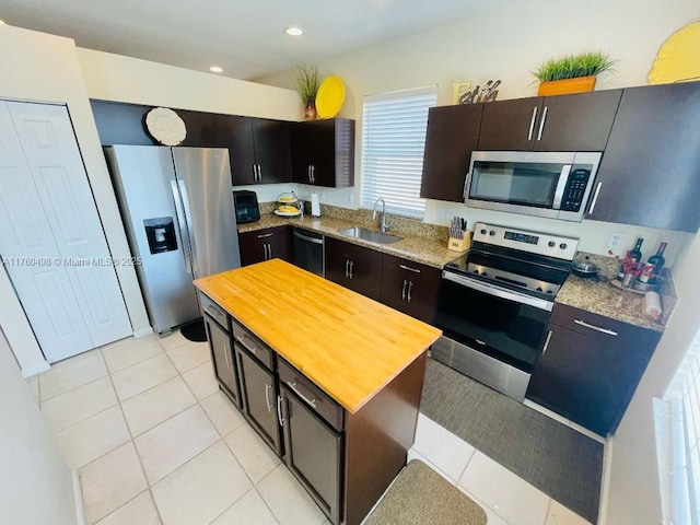 6938 NW 33rd St, Margate, FL 33063 - kitchen with stainless steel appliances, wooden counters, a sink, light tile patterned flooring, and a kitchen island
