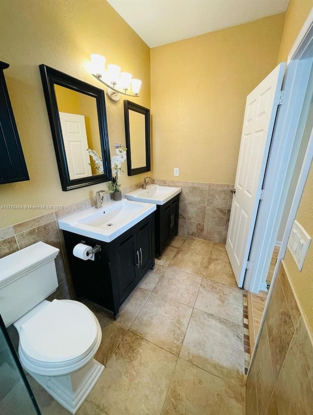 6938 NW 33rd St, Margate, FL 33063 - bathroom featuring tile walls, toilet, vanity, a wainscoted wall, and tile patterned flooring