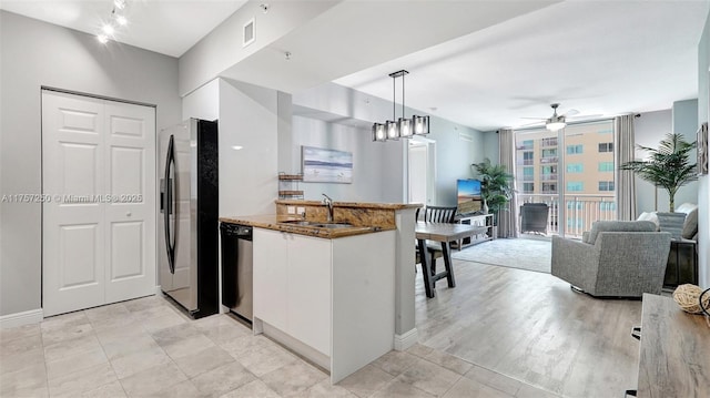 kitchen featuring a sink, a peninsula, white cabinets, stainless steel fridge with ice dispenser, and dishwasher