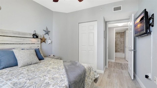 bedroom featuring visible vents, ceiling fan, baseboards, light wood-type flooring, and a closet