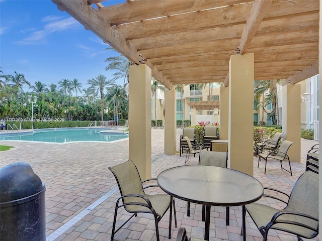 view of patio / terrace featuring outdoor dining area, a community pool, and a pergola