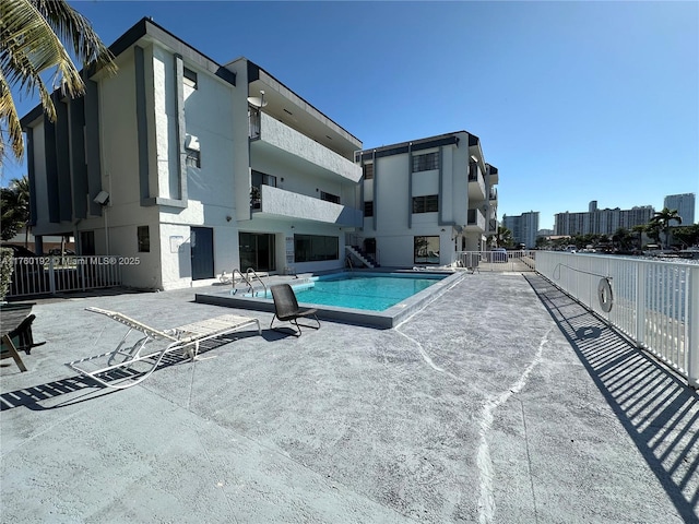 pool with a patio area and fence