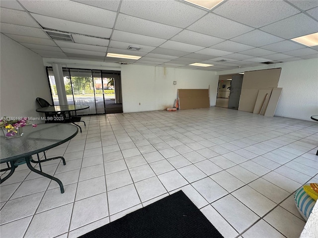 interior space featuring light tile patterned floors, a drop ceiling, and visible vents