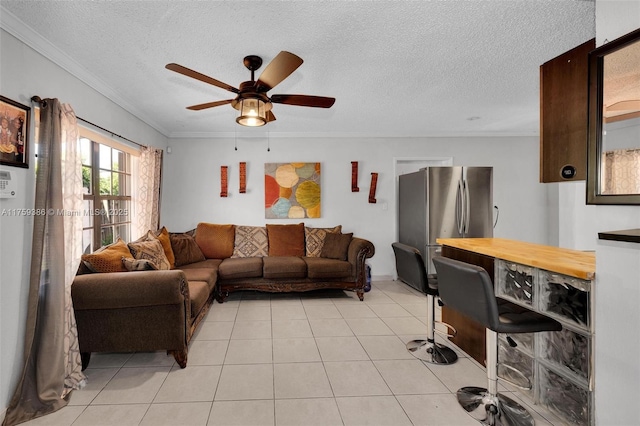 living room with ceiling fan, crown molding, light tile patterned flooring, and a textured ceiling