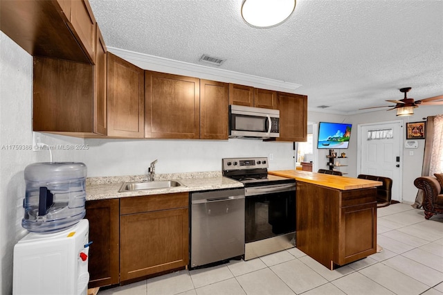 kitchen with visible vents, ceiling fan, appliances with stainless steel finishes, a peninsula, and a sink