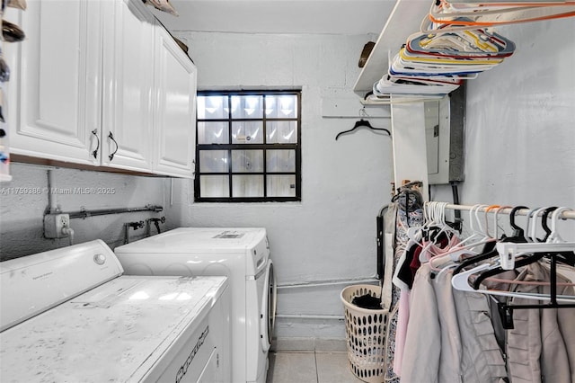 washroom with light tile patterned floors, cabinet space, and washer and clothes dryer