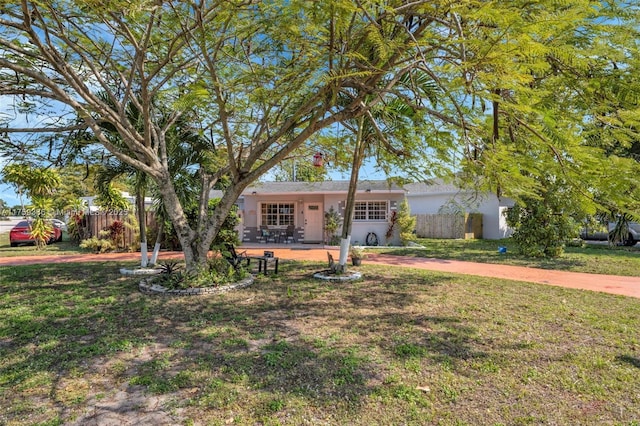 single story home with stucco siding, a front yard, and fence