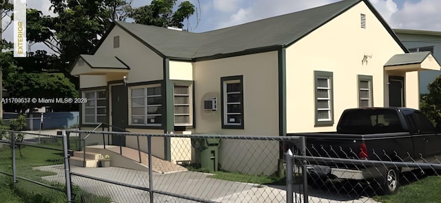 view of front of home with stucco siding and fence