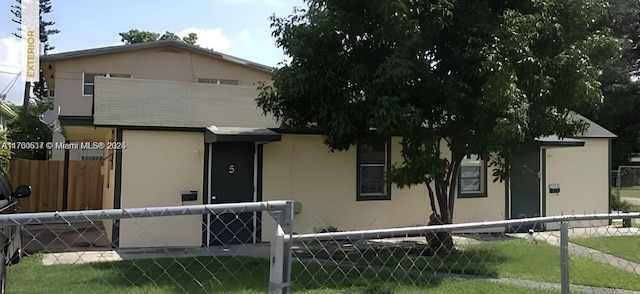 view of front of home featuring stucco siding and fence private yard