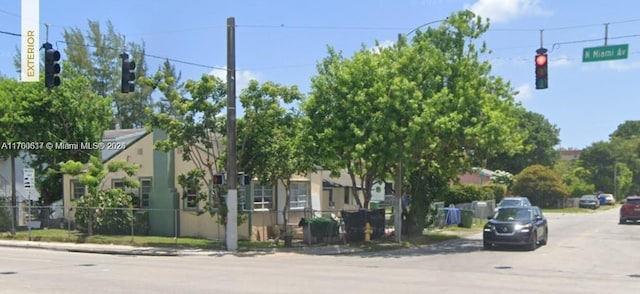 view of road featuring curbs, traffic lights, and sidewalks