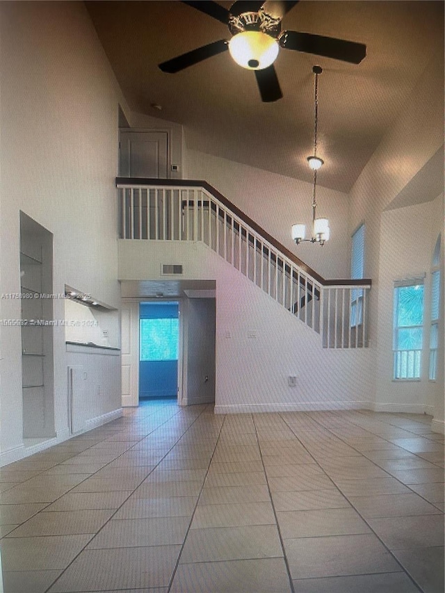 unfurnished living room with tile patterned flooring, visible vents, and a high ceiling