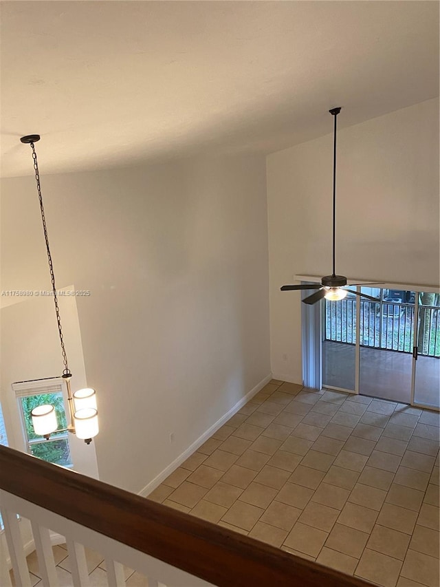 spare room with a ceiling fan and baseboards