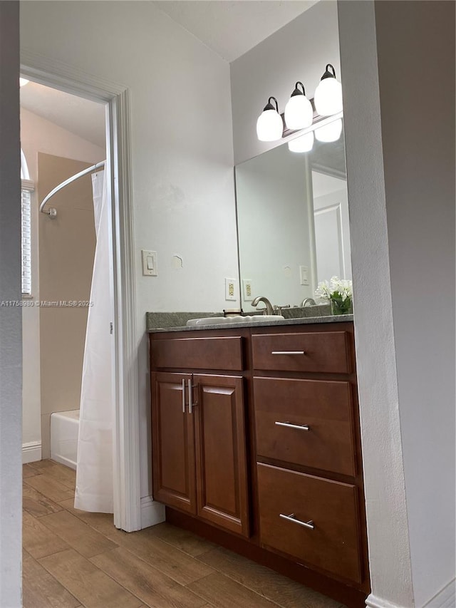 full bathroom with vanity, wood finished floors, and shower / tub combo