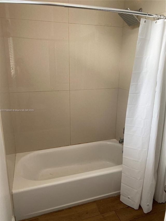 bathroom with wood finished floors and shower / tub combo