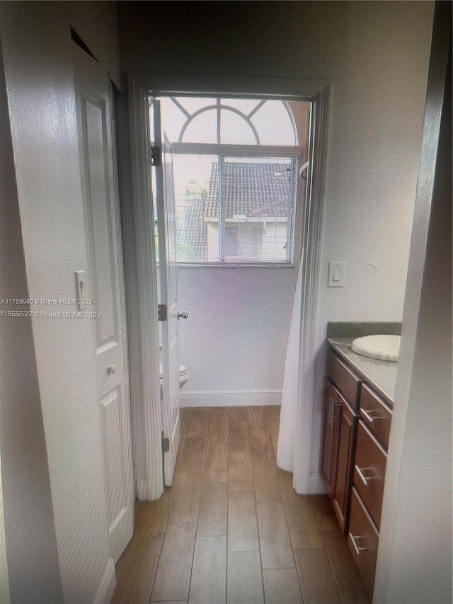 full bath with toilet, vanity, and wood finished floors