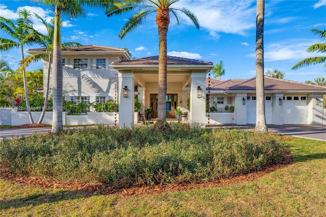 mediterranean / spanish-style house with a tile roof, a garage, and stucco siding