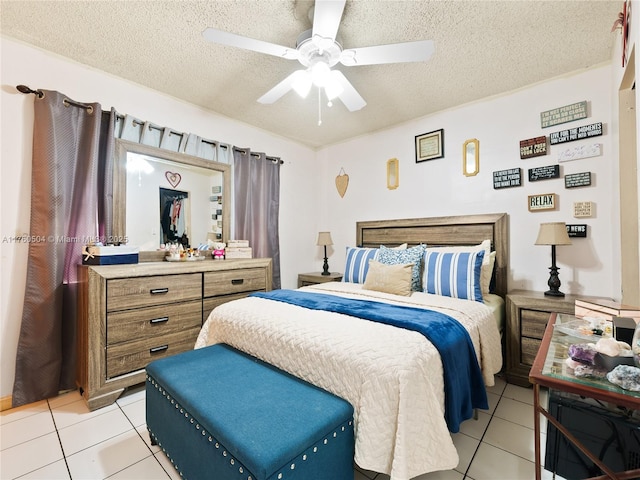 bedroom with a textured ceiling, light tile patterned flooring, and a ceiling fan