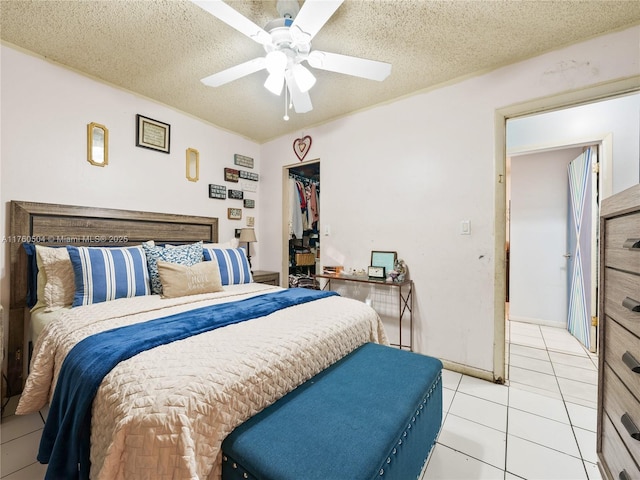 bedroom featuring light tile patterned floors, a closet, a textured ceiling, and ceiling fan