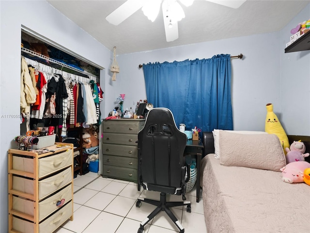 bedroom featuring light tile patterned floors, a closet, and ceiling fan