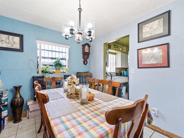 dining area featuring a notable chandelier, light tile patterned flooring, and a textured wall