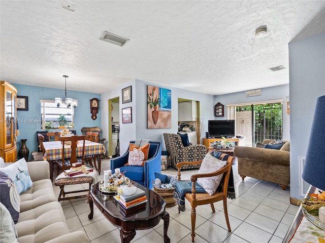 living room with light tile patterned floors, visible vents, a textured ceiling, and a chandelier