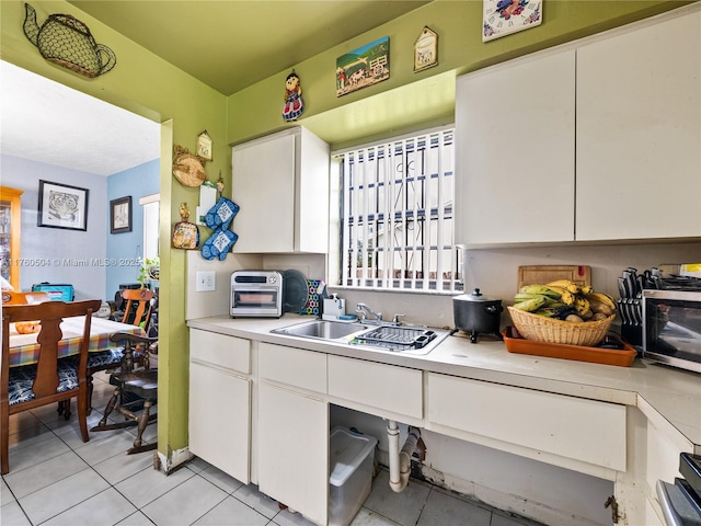 kitchen featuring a sink, white cabinetry, light tile patterned floors, and light countertops