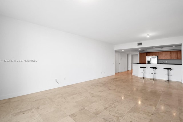 unfurnished living room featuring recessed lighting and visible vents