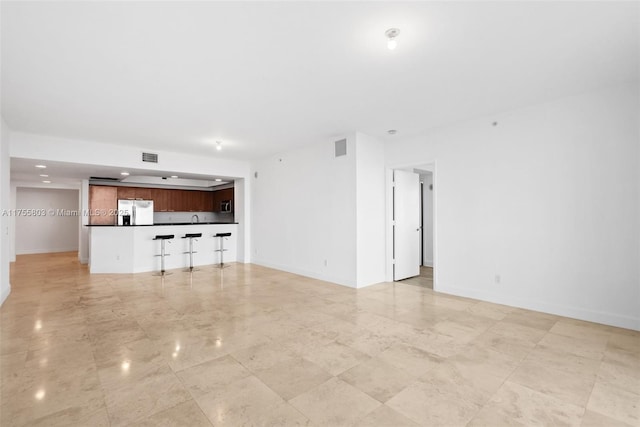 unfurnished living room with visible vents and baseboards