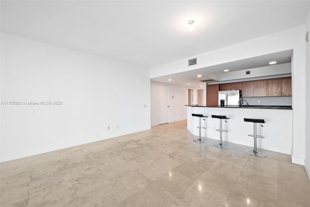 unfurnished living room featuring recessed lighting, visible vents, and baseboards