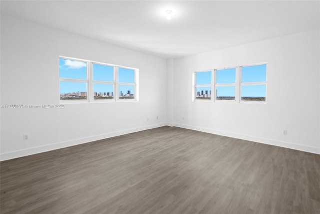 unfurnished room featuring dark wood finished floors and baseboards