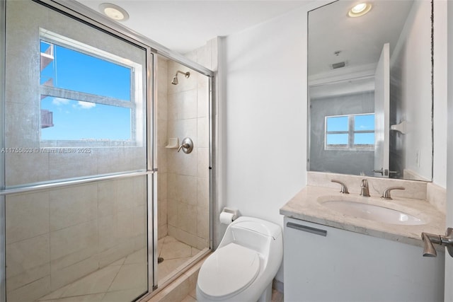 full bathroom with visible vents, vanity, a shower stall, and toilet