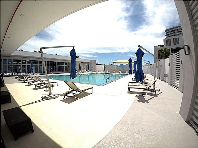 pool with a patio and fence