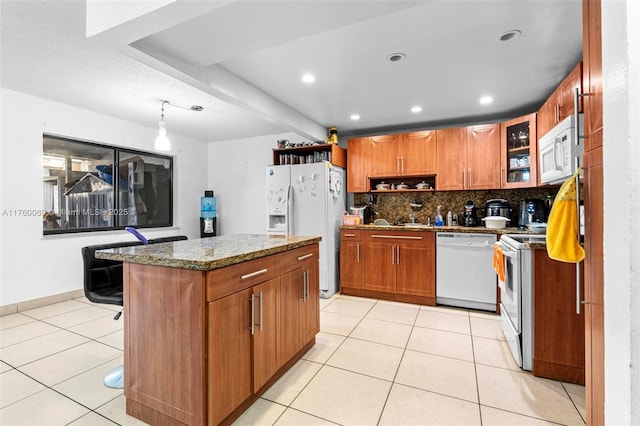 kitchen featuring light tile patterned floors, decorative backsplash, white appliances, and stone counters