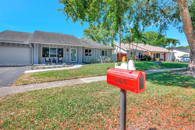 ranch-style home with a front lawn, an attached garage, driveway, and a shingled roof