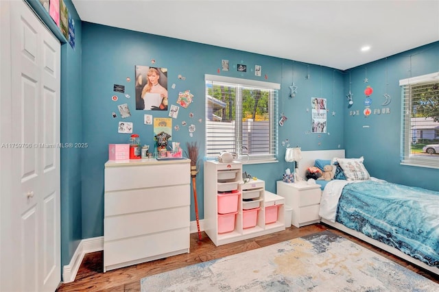 bedroom featuring a closet, baseboards, and wood finished floors