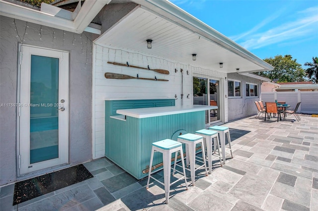 view of patio / terrace featuring outdoor dry bar, outdoor dining area, and fence