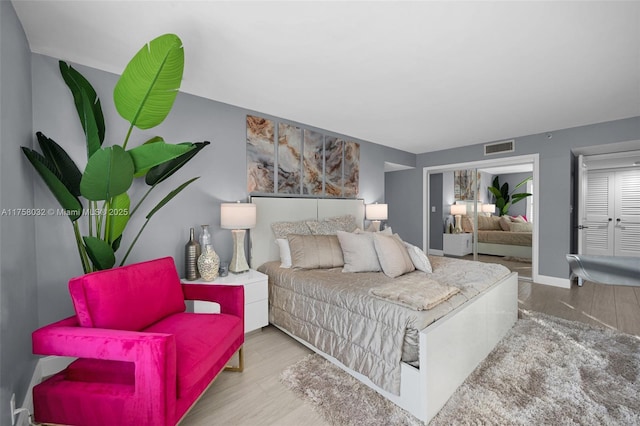 bedroom featuring wood finished floors, visible vents, and baseboards