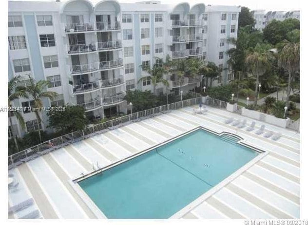 community pool with a patio and fence