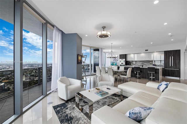 living area featuring recessed lighting, a notable chandelier, floor to ceiling windows, and light tile patterned floors