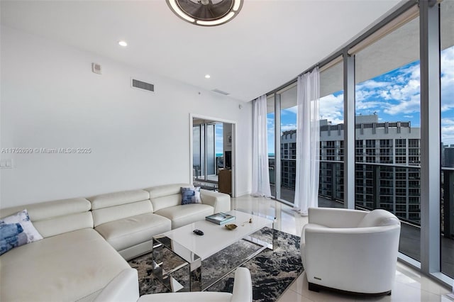 living area featuring floor to ceiling windows, visible vents, and recessed lighting