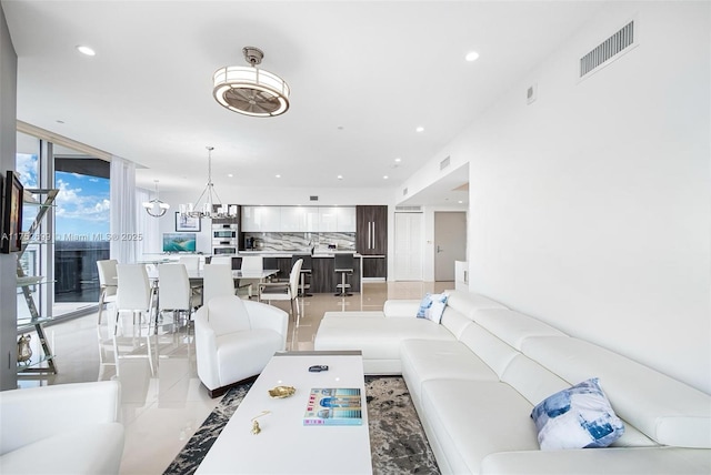 living room with recessed lighting, visible vents, an inviting chandelier, and light tile patterned flooring