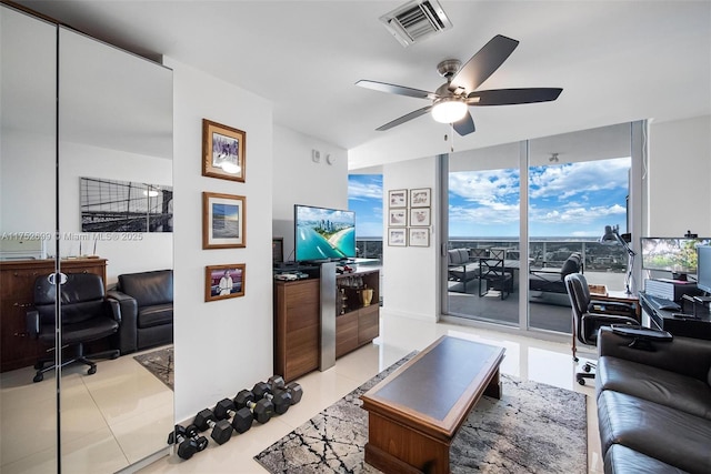 living area featuring floor to ceiling windows, light tile patterned flooring, a ceiling fan, and visible vents