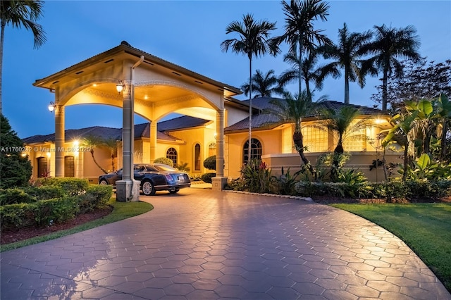 view of front of home with decorative driveway and stucco siding